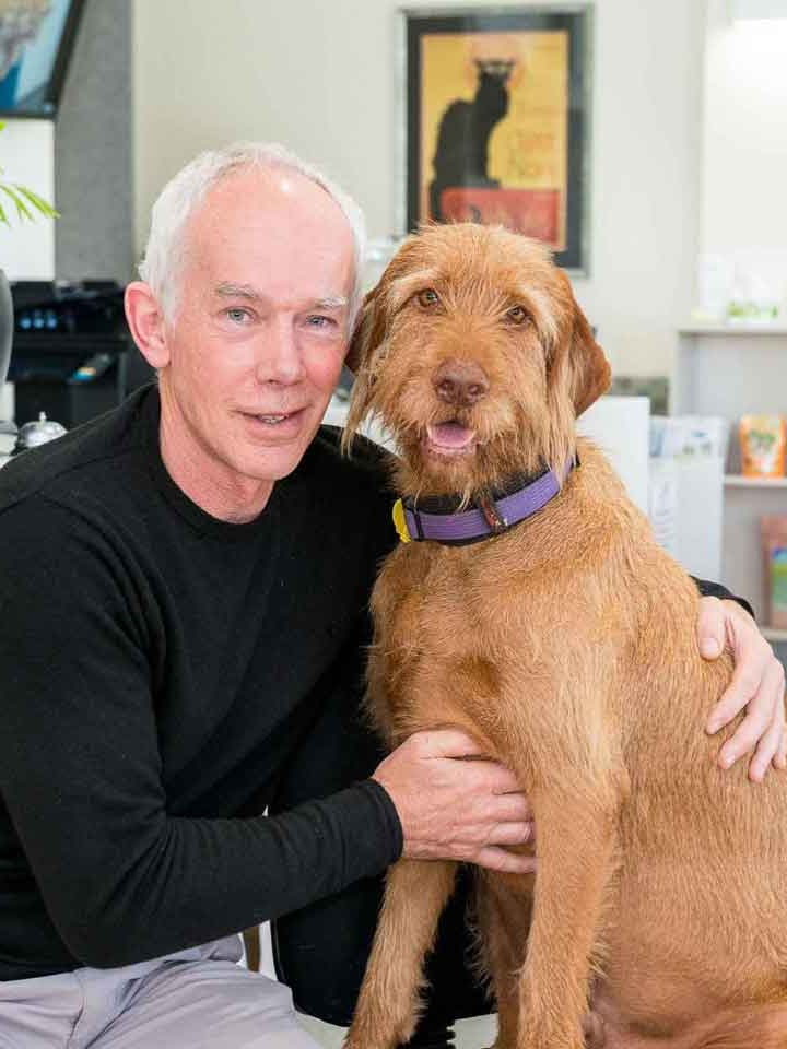 Man wearing black with tan coloured dog