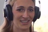 A woman looks into the camera while wearing headphones. A caption reads "I am Lexi Rodgers".