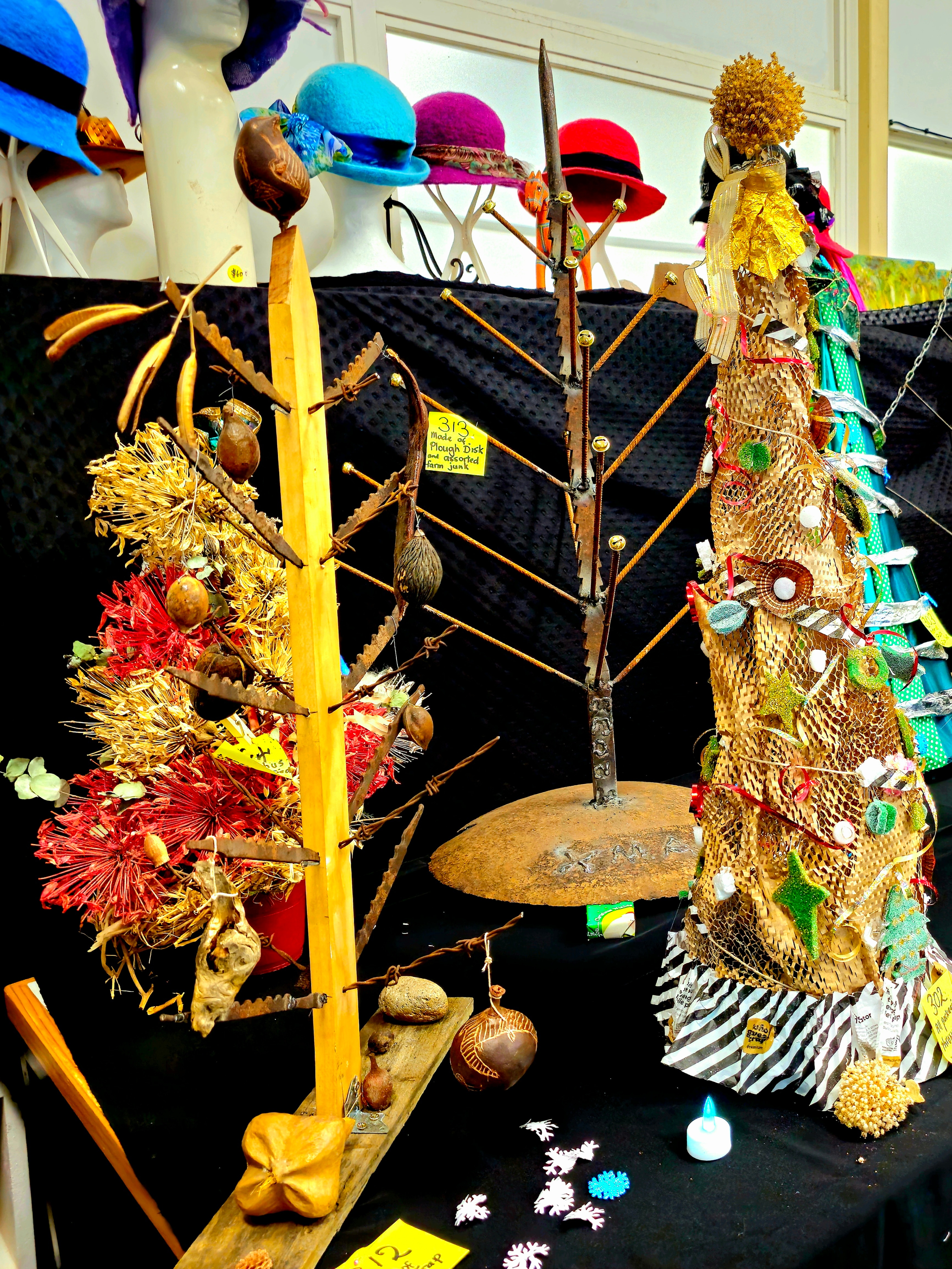 Homemade recycled Christmas trees including one wiht metal "branches" with tooth-like edges (made from a rabbit trap).