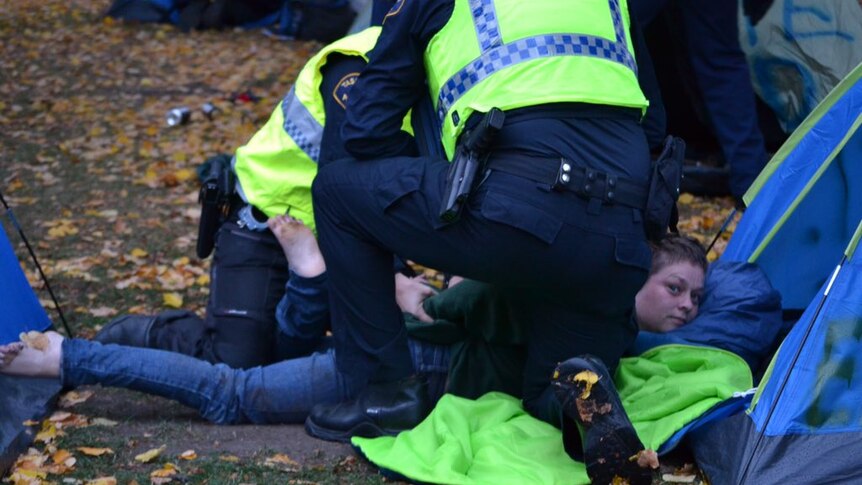 Tasmania Police handcuff a homelessness protester at Parliament in Hobart.