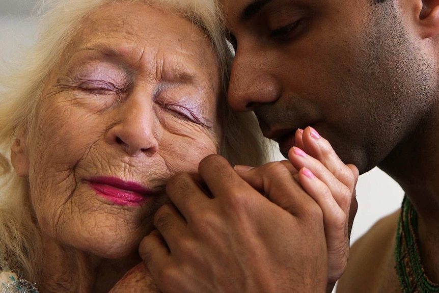 Headshot of  Eileen Kramer, 103, dancing cheek to cheek with a young male dancer