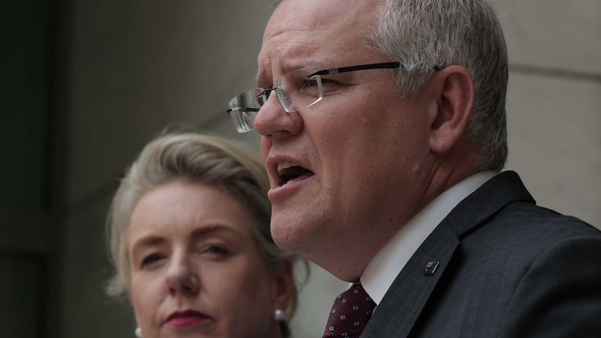 Bridget McKenzie looks at Scott Morrison as he speaks at a press conference