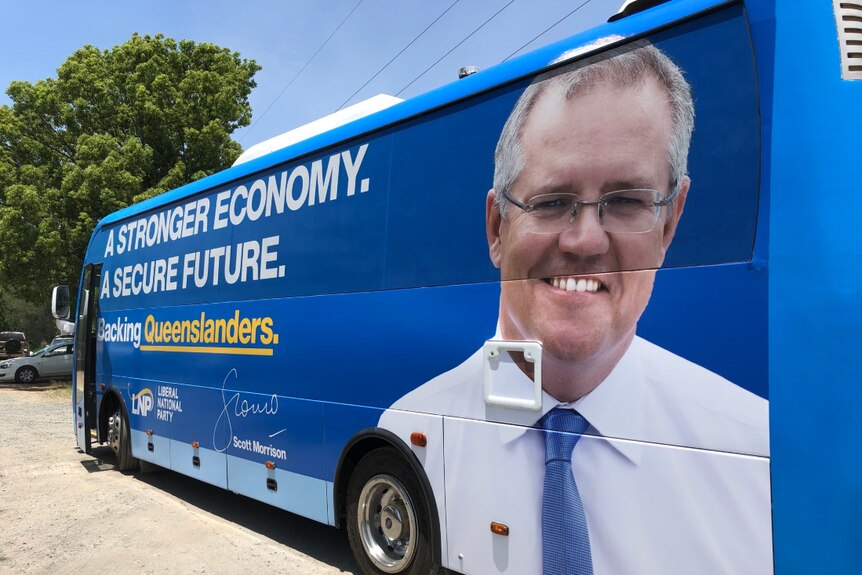 A blue bus with the prime minister's face on the back and political slogans written across the windows