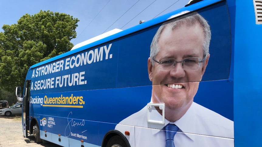 A blue bus with the prime minister's face on the back and political slogans written across the windows