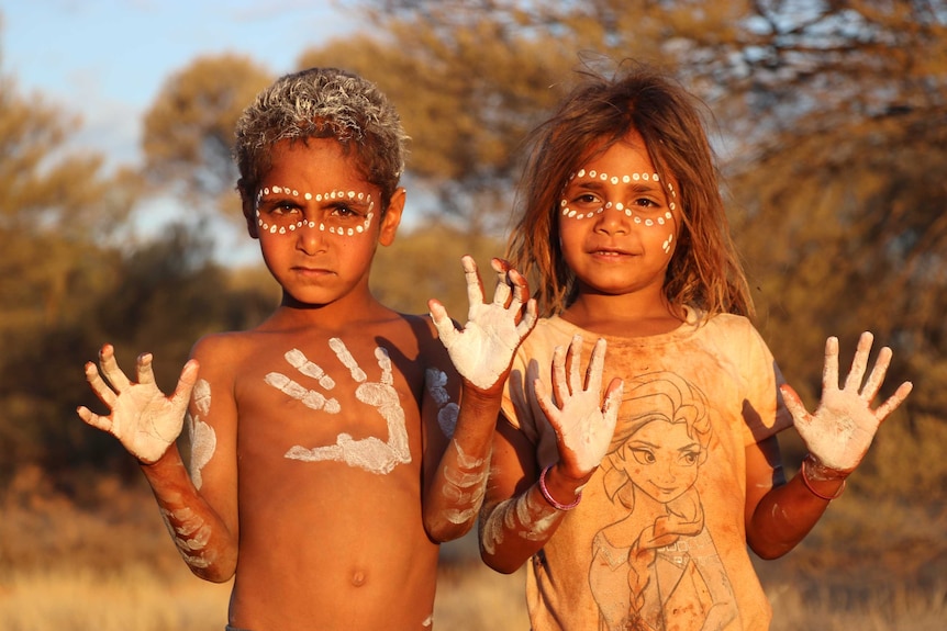 Two young Aboriginal children wearing cultural paint.