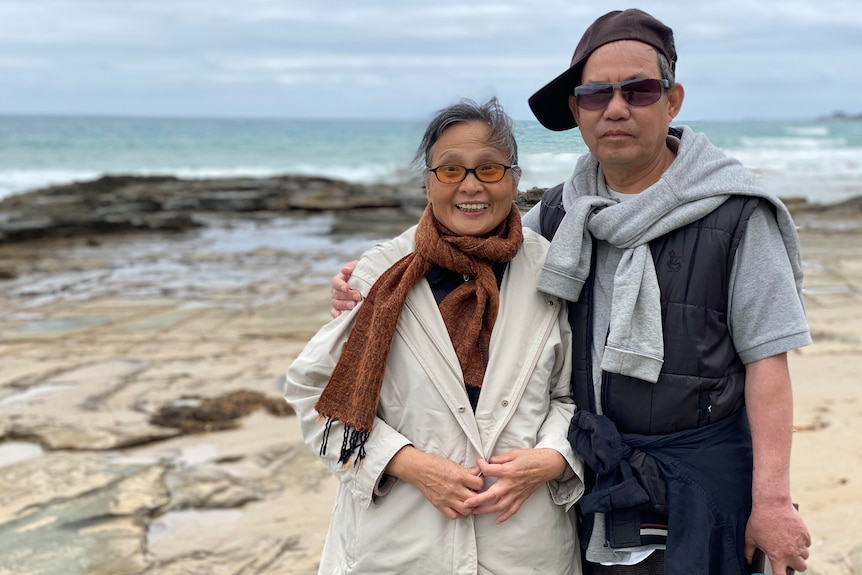 Grace Feng Fang Juan's parents pose for a photo in front of the water in the Victorian town of  Lorne.