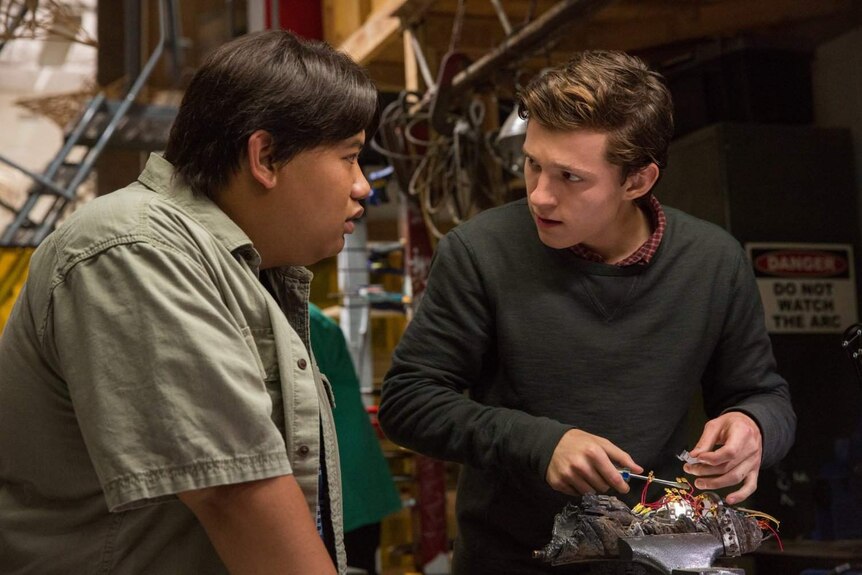 Jacob Batalon, playing Spider-Man's best friend Ned, speaks with Tom Holland as he tinkers with wiring.