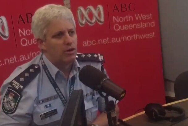 A man in a police uniform talks into a microphone at ABC radio studios.