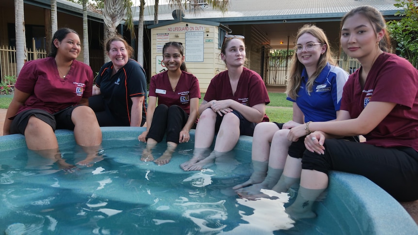 young women dip their feet in a pool spa at a hotel
