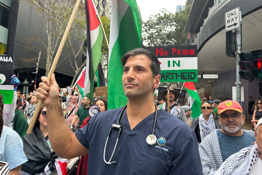 Doctor Ahmad Abou-sweid holds a Palestinian flag at a rally.