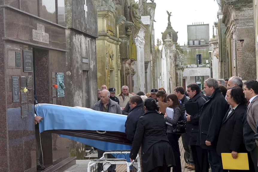 The remains of Formula One great Juan Manuel Fangio are taken out of his tomb in Balcarce's cemetery