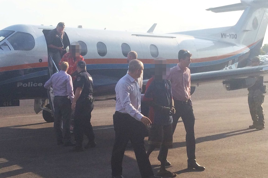NT Police escort men from Groote Eylandt from a plane.
