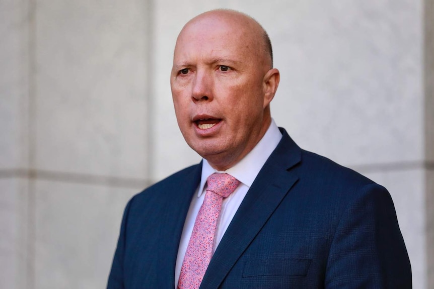 Peter Dutton speaking against a white background.