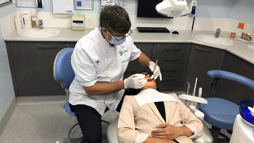 Dentist with a patient in a dental chair.
