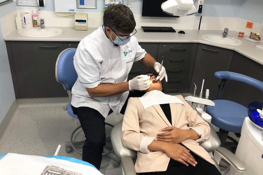 Dentist with a patient in a dental chair.
