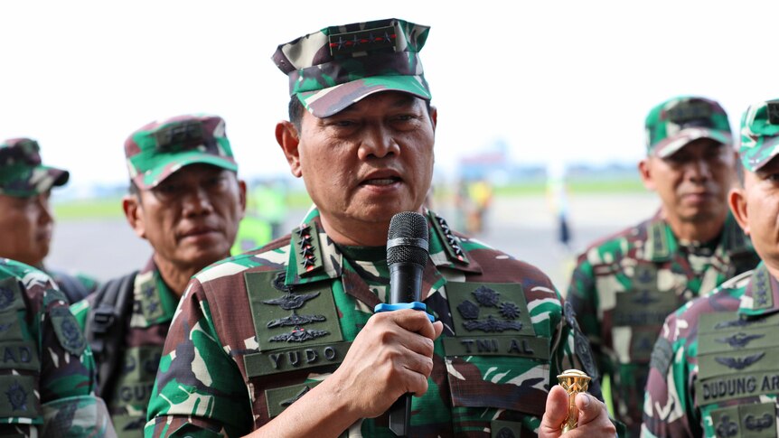 Indonesian Armed Forces Chief Yudo Margono addresses a media conference. He is flanked by a group of uniformed army personnel.