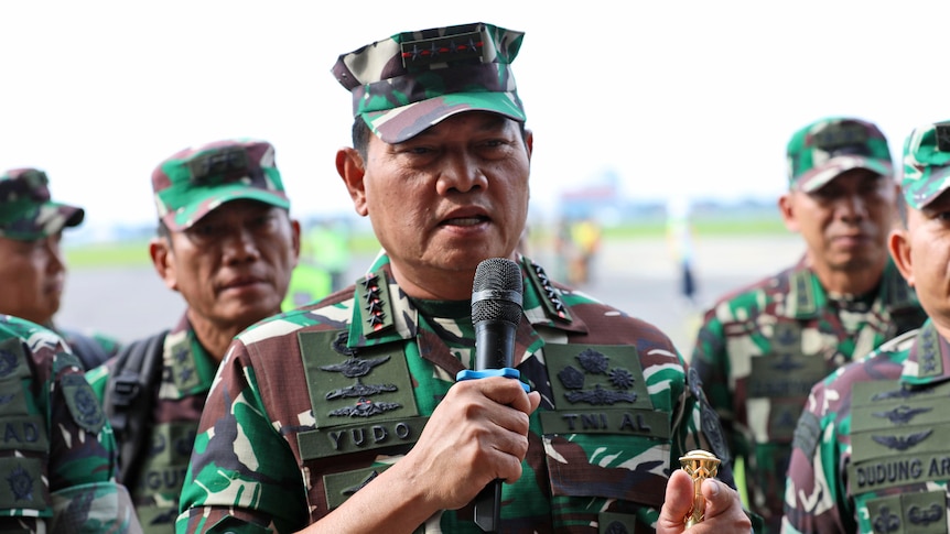 Indonesian Armed Forces Chief Yudo Margono addresses a media conference. He is flanked by a group of uniformed army personnel.