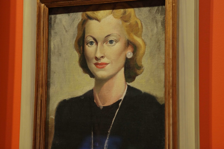 A painting of a woman in a brown frame.