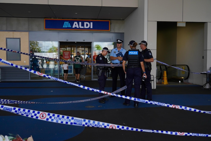 Police tape and police officers outside an Aldi store at Redbank Plains Shopping Centre.