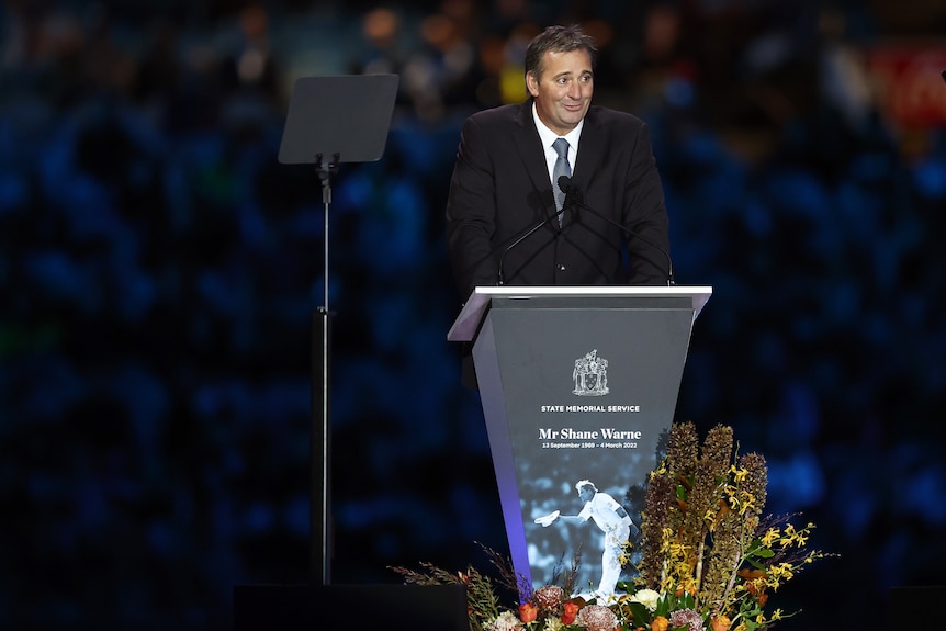 Shane Warne's brother, Jason, speaks at a lectern at a memorial at the MCG.