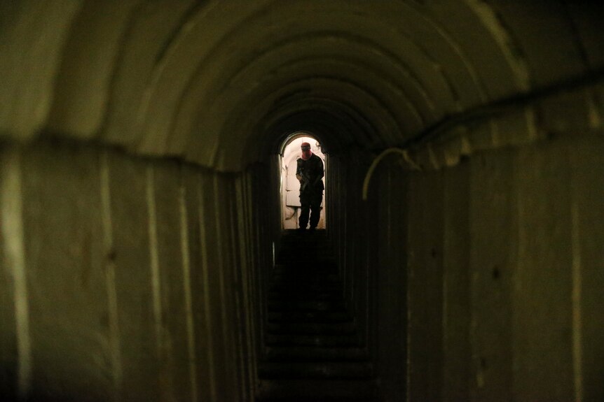 A man standing at the end of a dark tunnel 