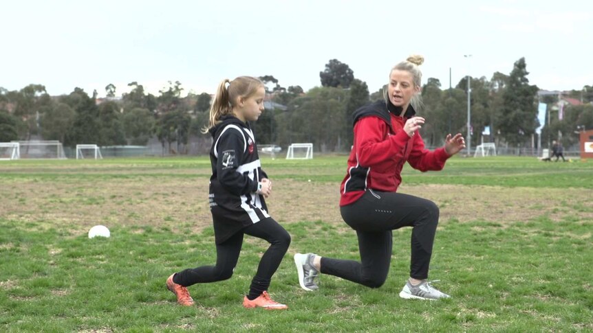 Brooke Patterson demonstrates knee exercises to a junior footballer