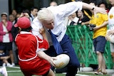 London's Mayor Boris Johnson collides with 10-year-old Toki Sekiguchi during a game of Street Rugby in Tokyo.