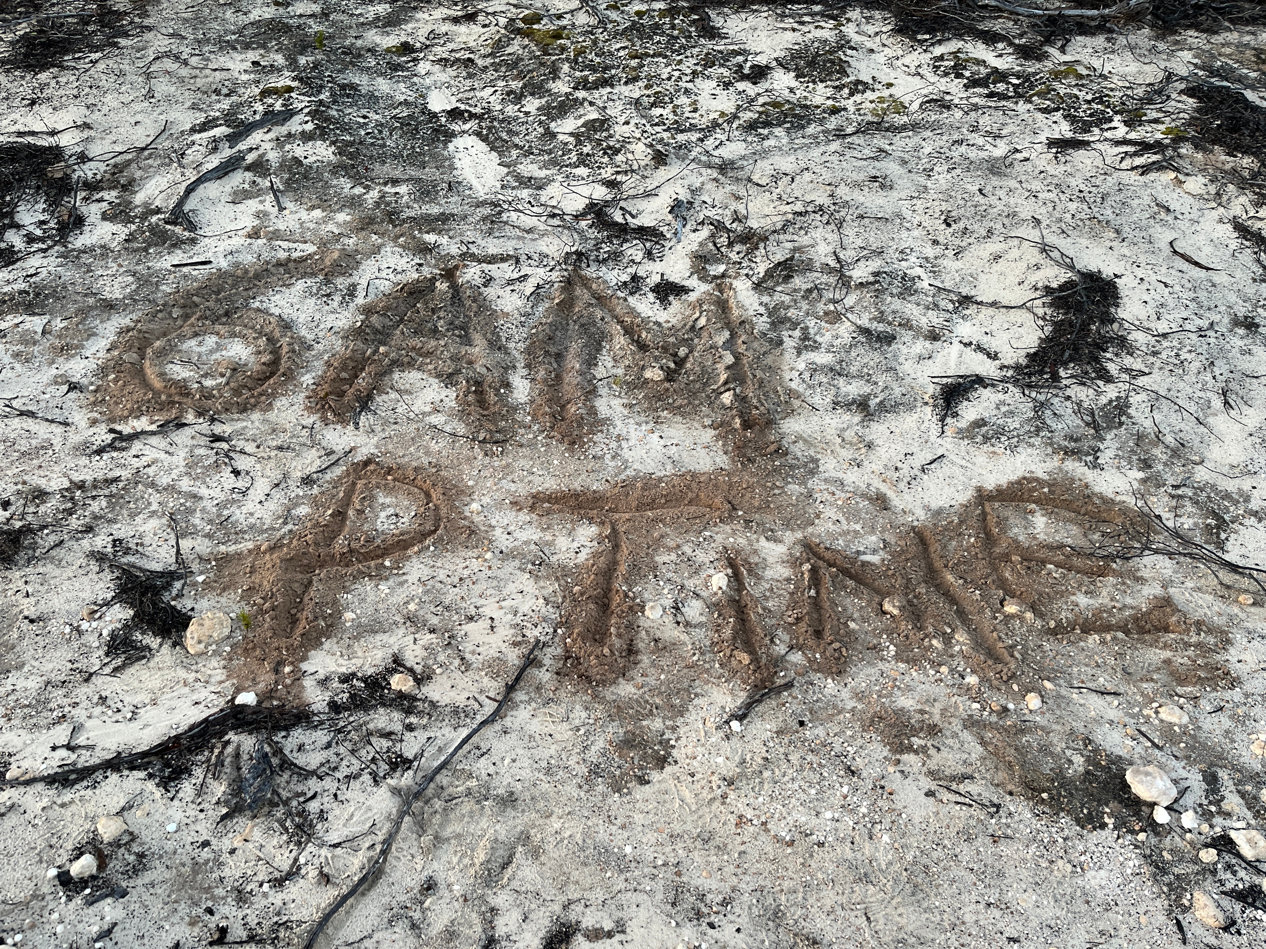 6am P Time is written in the sand