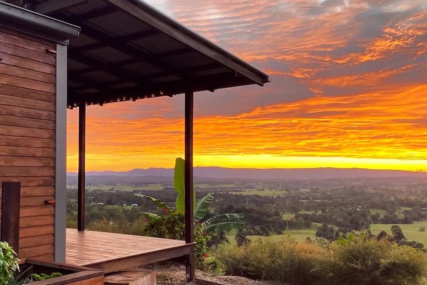 Looking past the deck and house to a stunning sunset.