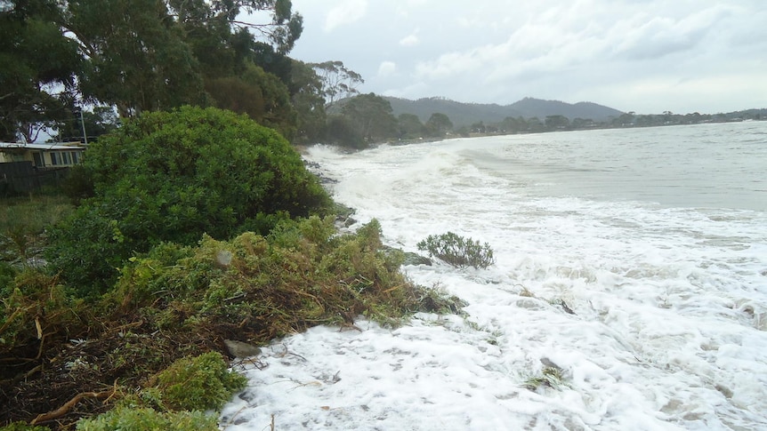 The sea washes into dunes during a storm at Lauderdale in southern Tasmania.