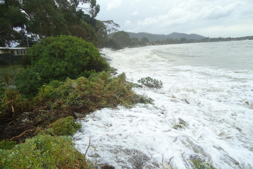 The sea washes into dunes during a storm at Lauderdale in southern Tasmania.