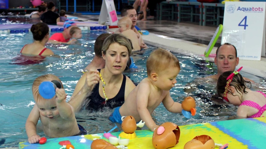Olympian Regan Harrison (right) with his daughter Leilani and other participants in the World's Largest Swimming Lesson.