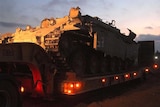 Israeli armoured personnel carrier sits on a trailer waiting for redeployment