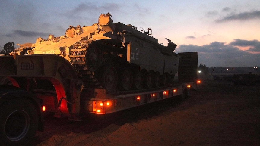 Israeli armoured personnel carrier sits on a trailer waiting for redeployment