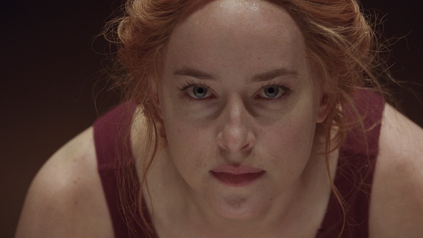 Colour close-up still of Dakota Johnson in 2018 film Suspiria.