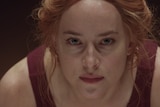 Colour close-up still of Dakota Johnson in 2018 film Suspiria.