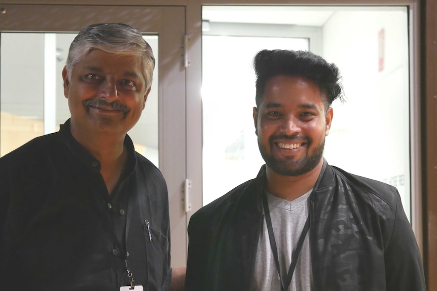 Two Indian men smile for the camera