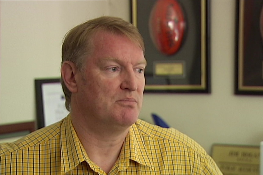 a photo of a man speaking right of camera