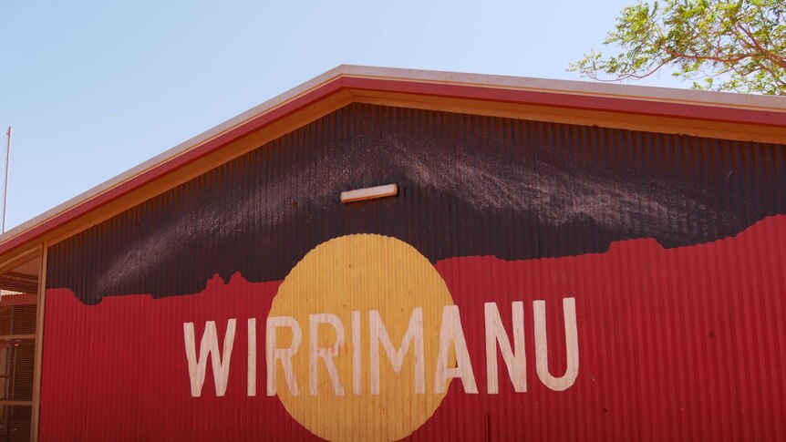 A large, barn-like building with an aboriginal flag and 'Wirrimanu' emblazoned on its corrugated cladding.