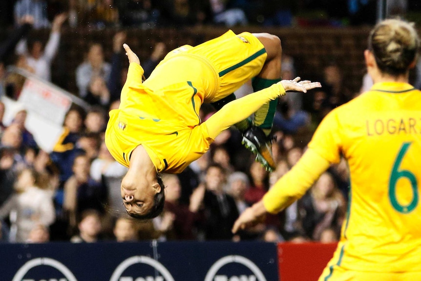 Sam Kerr does a backflip after scoring a goal.