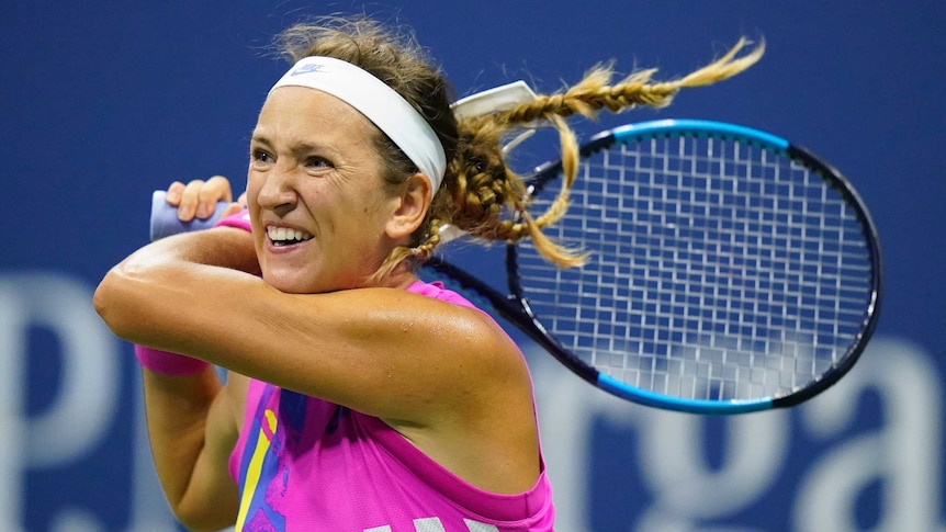 Victoria Azarenka grimaces as she holder her racquet in both hands behind her head