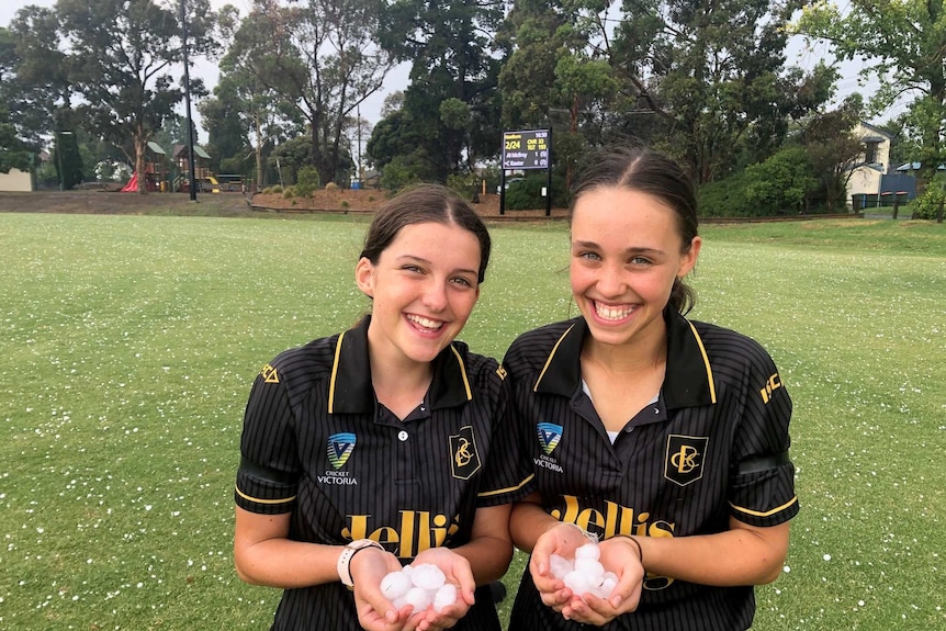Two young girls holding hail and smiling