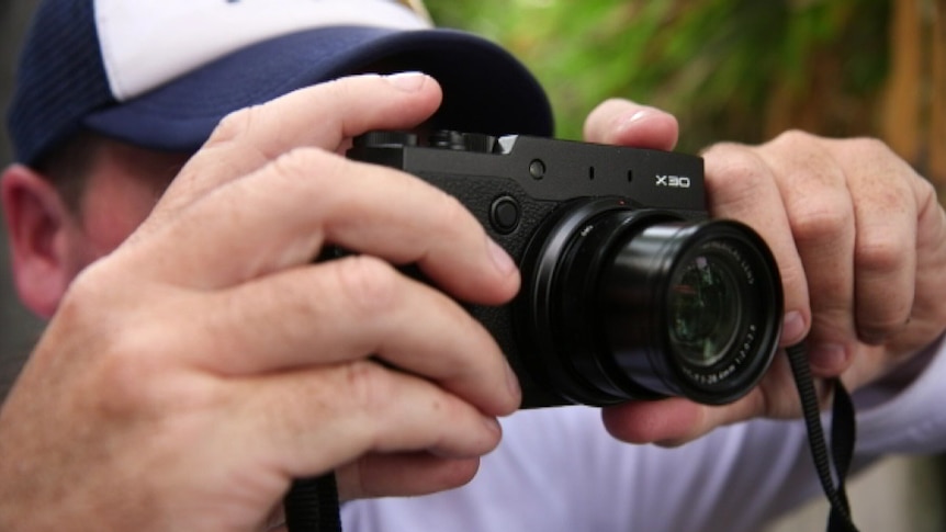 Animals Australia investigator Luke takes photos with a camera.