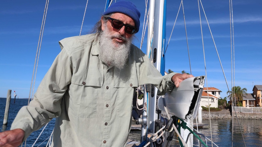 Bearded man onboard yacht on left broken aluminium boom on right