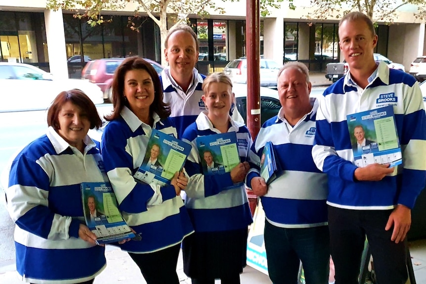 A group of people stands with flyers