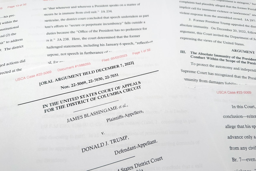 A close-up view of a stack of papers shows a lawsuit filed against former US president Donald Trump.