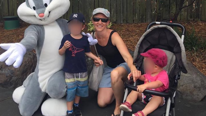 A woman in shorts and sunglass with two small children and another person in a rabbit costume