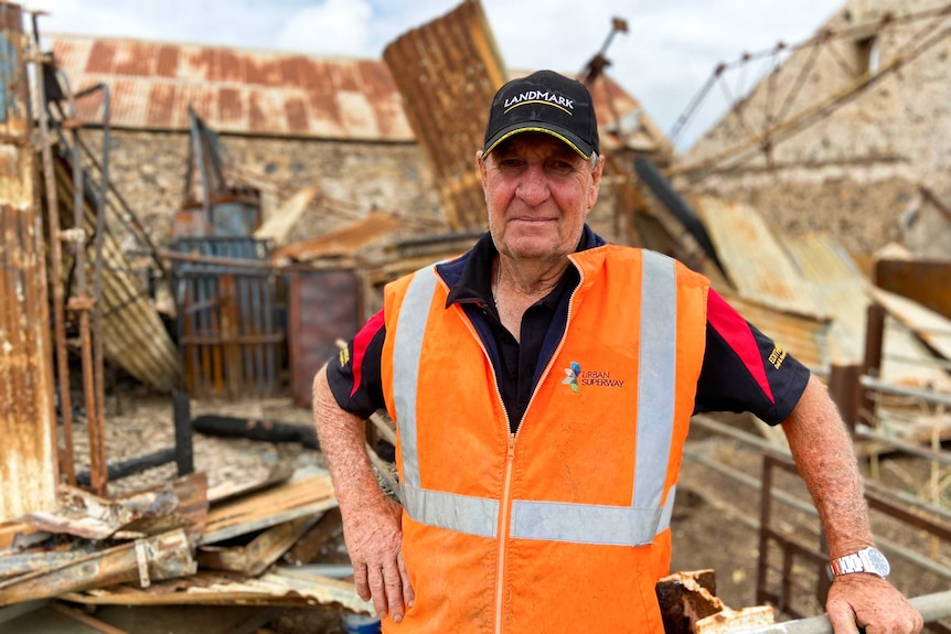 Farmer Mark Hewton in front of a fire-damaged farm shed.