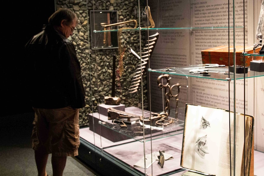 A tourist looks at the Radcliffe Collection at the Port Arthur site