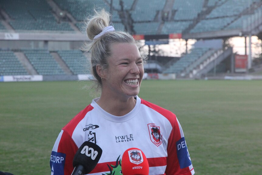 Woman smiling in a Dragons jersey being interviewed